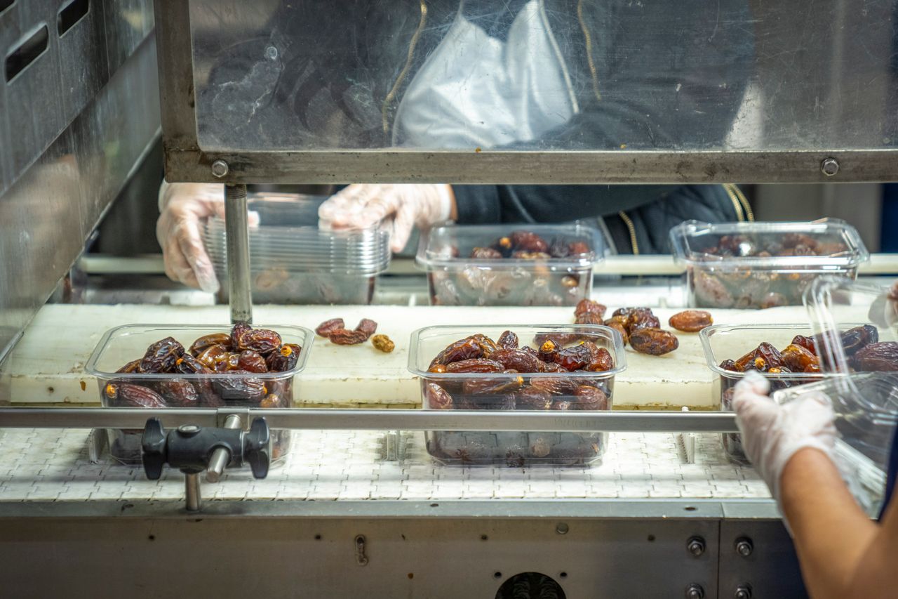 Employés conditionnant des produits alimentaires en usine.