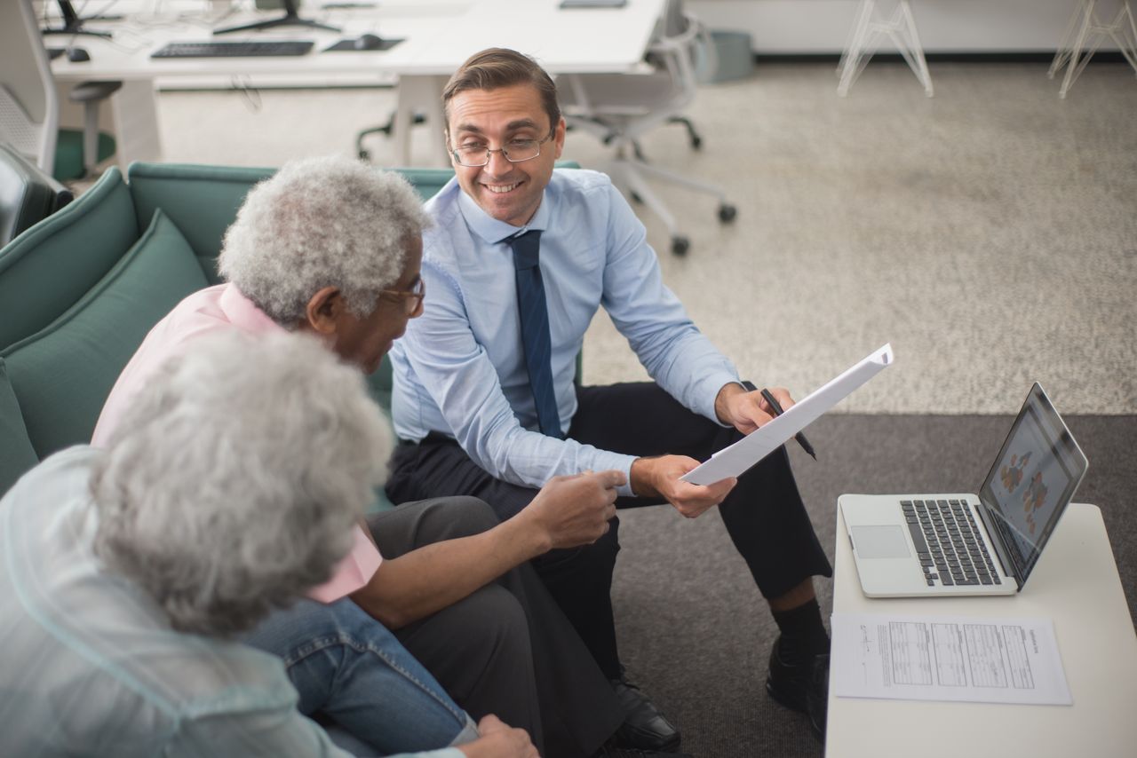 Conseiller présentant un plan financier à des clients dans un bureau.