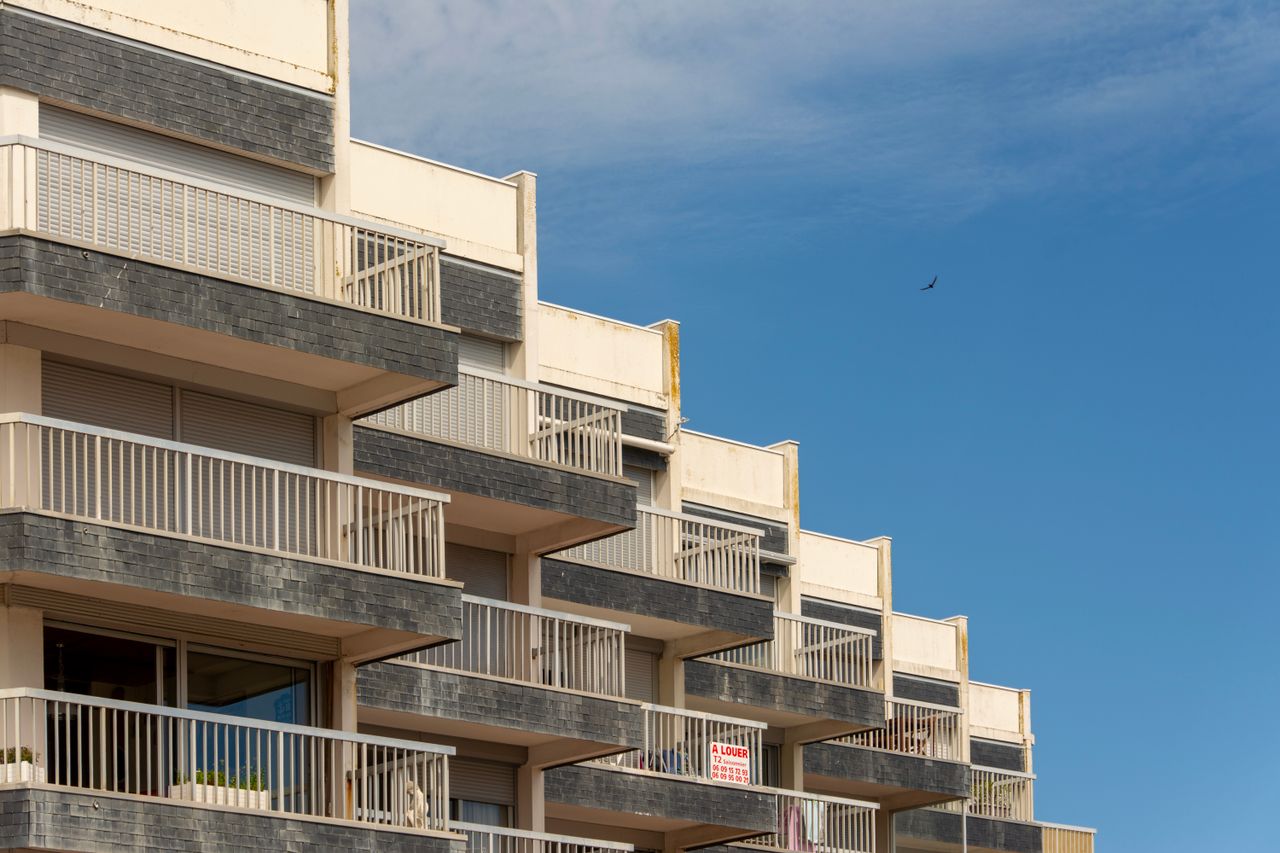 Façade d’un immeuble résidentiel moderne aux balcons rythmés.