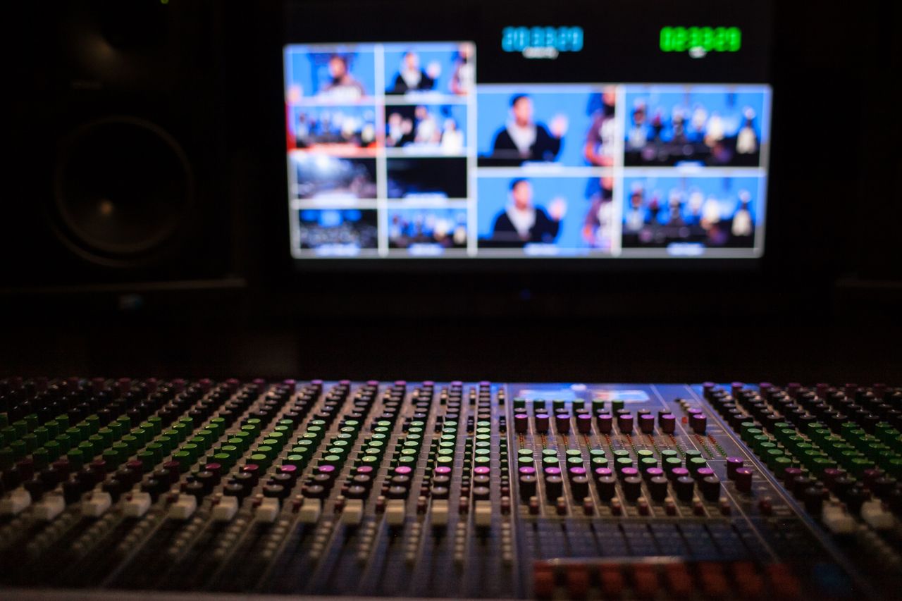 Régie de production avec console de mixage et écrans de contrôle.