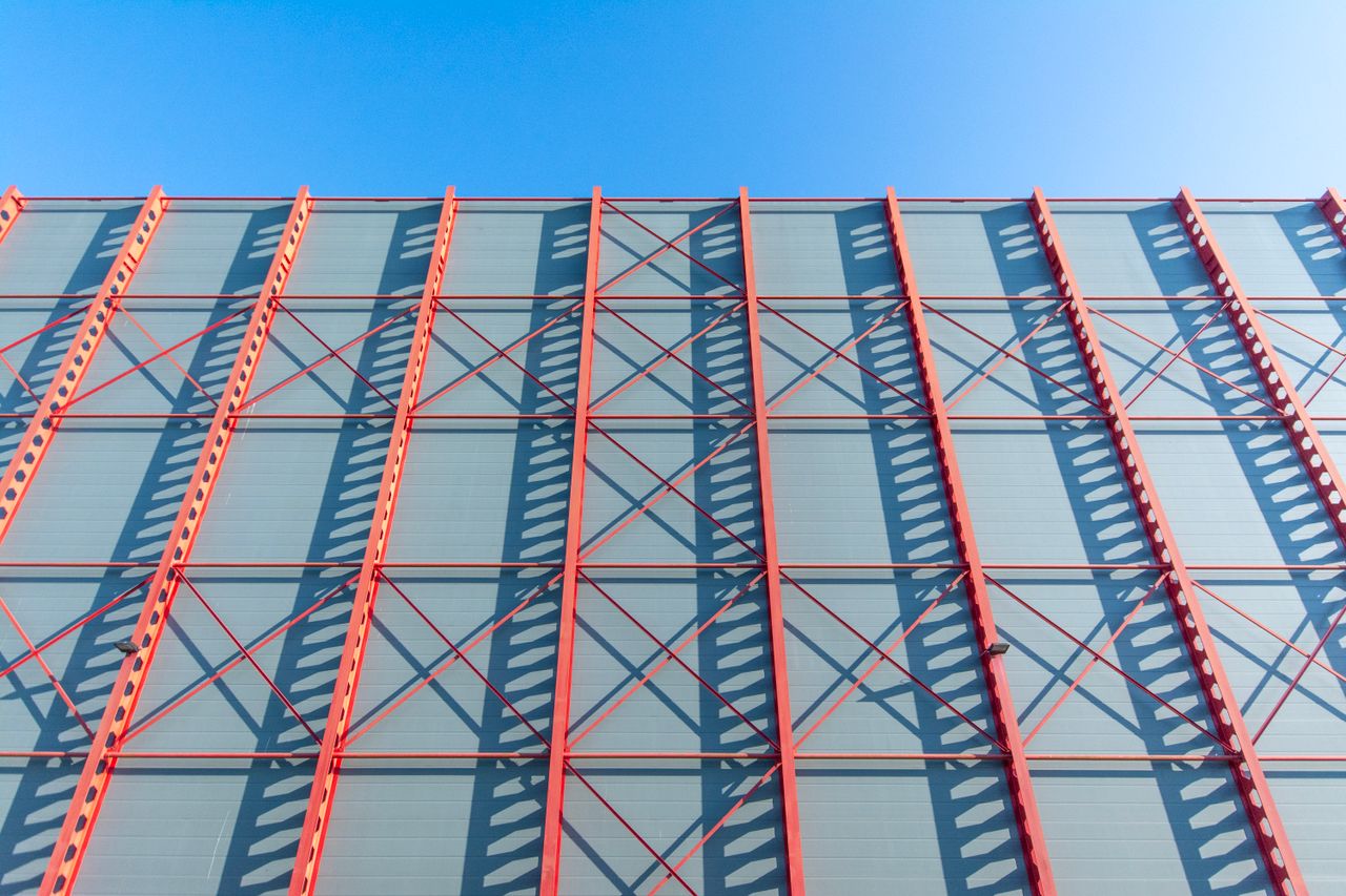 Structure métallique d’un bâtiment en construction sous un ciel dégagé.