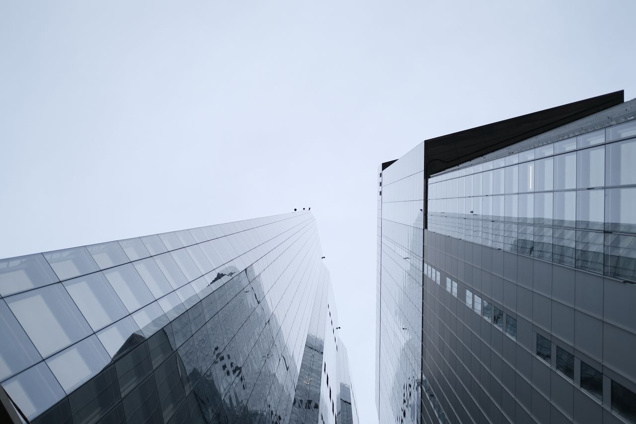 Tours de verre d’un quartier financier reflétant la ville.