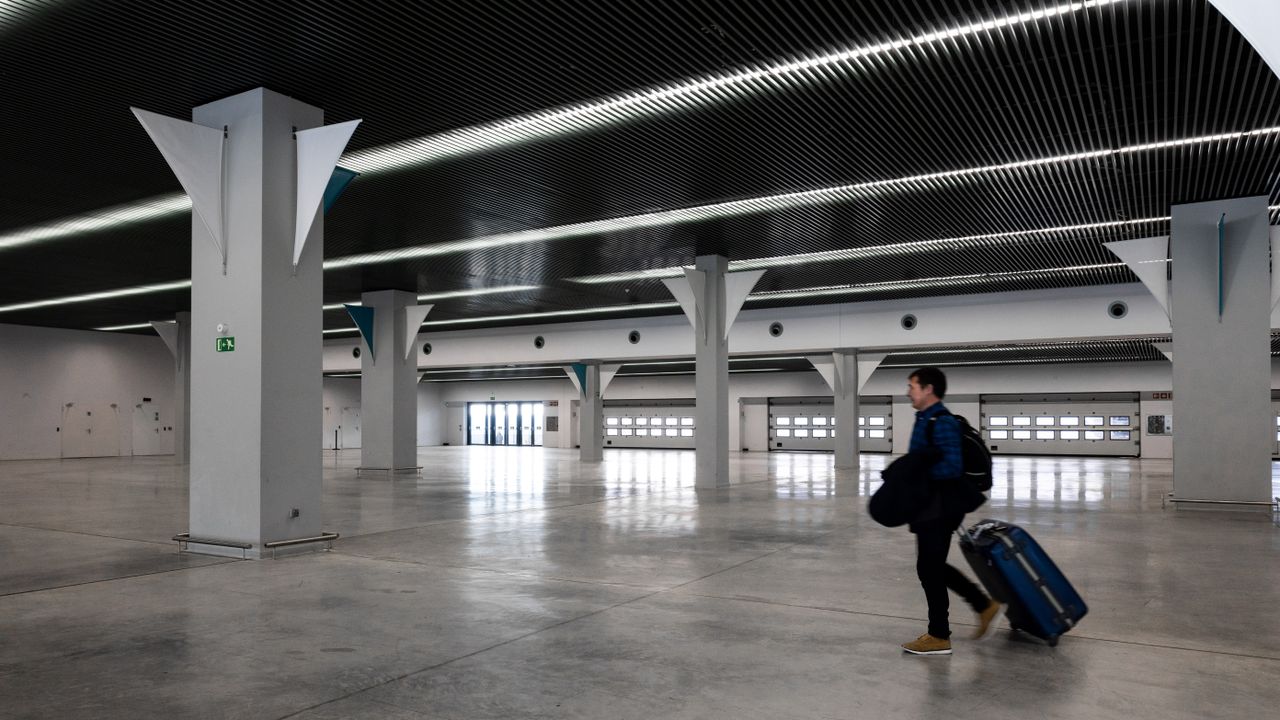Voyageur traversant un hall d’aéroport moderne et spacieux.